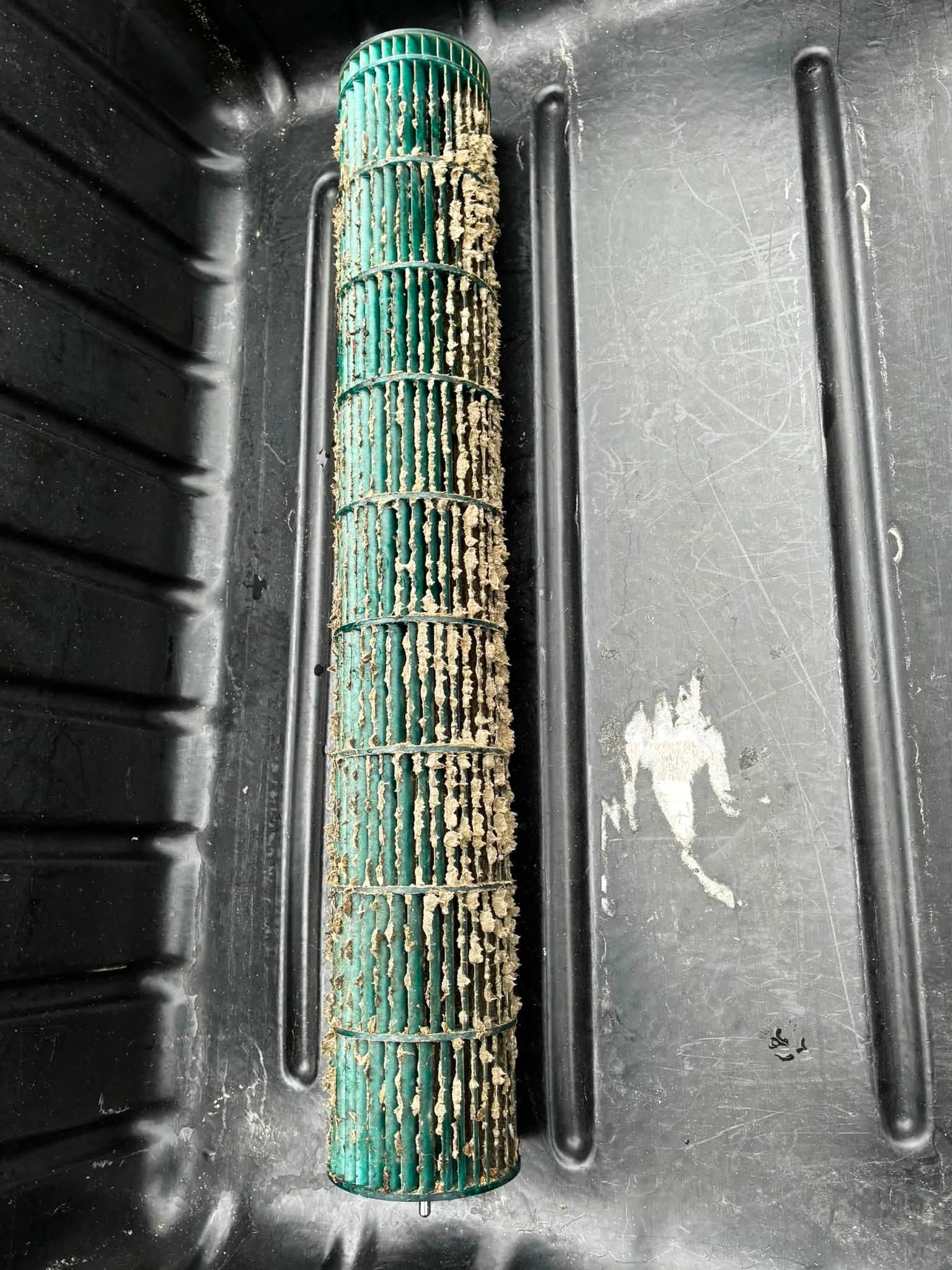 Blower wheel caked with debris in a wash tray